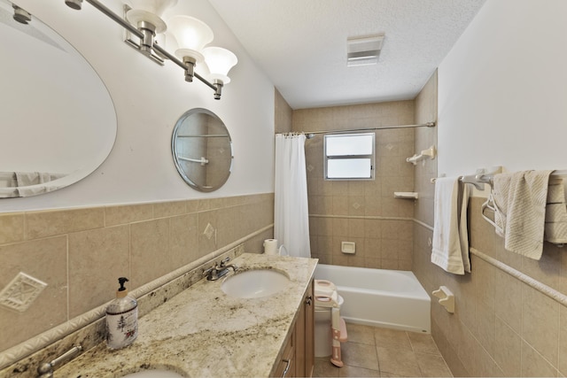 full bathroom featuring shower / bath combo, tile patterned floors, a textured ceiling, tile walls, and toilet