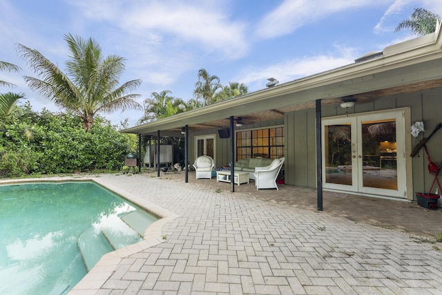 view of swimming pool featuring ceiling fan, a patio area, and french doors