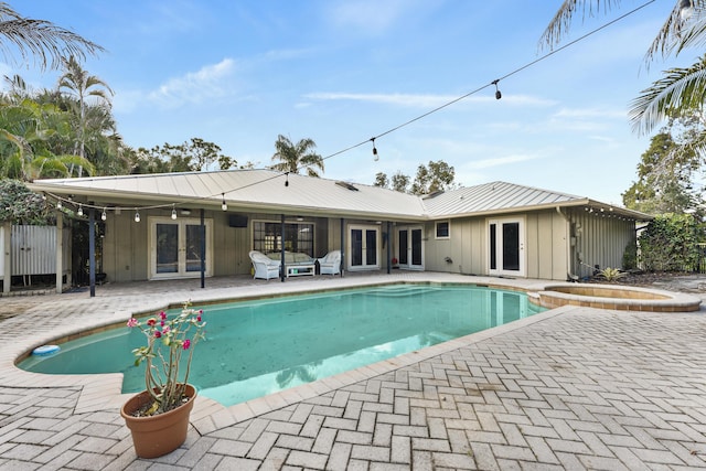 view of swimming pool with an in ground hot tub, french doors, and a patio