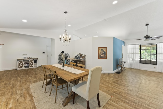 dining area with ceiling fan with notable chandelier, light hardwood / wood-style flooring, and lofted ceiling