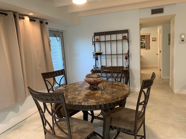 dining space with beam ceiling