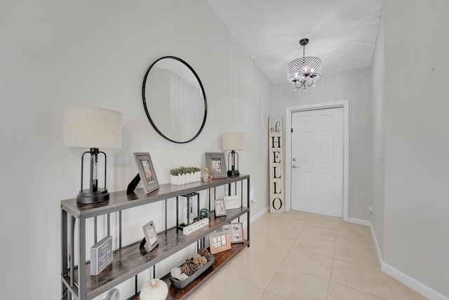 tiled entryway featuring a notable chandelier