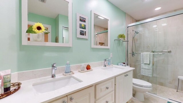 bathroom with vanity, toilet, tile patterned flooring, and a shower with door