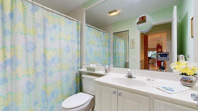 bathroom featuring vanity, walk in shower, and toilet