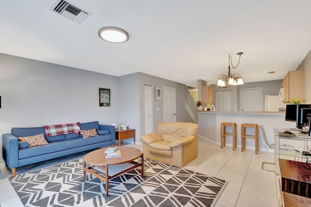 tiled living room with a notable chandelier