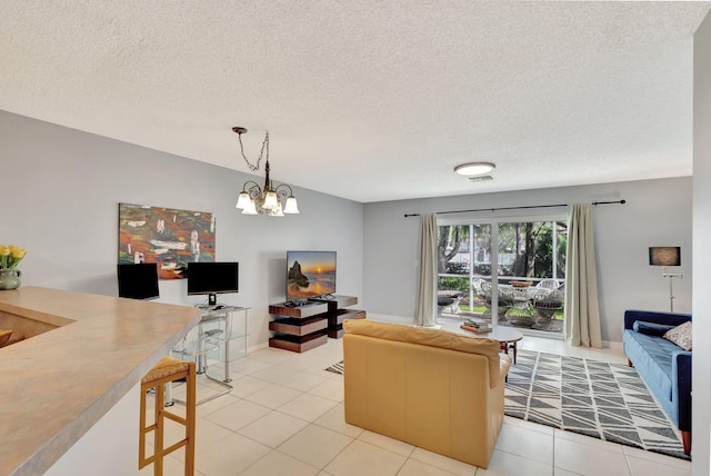 living room with a notable chandelier, light tile patterned floors, and a textured ceiling