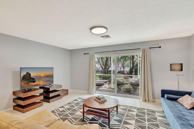 living room featuring a textured ceiling and light tile patterned floors