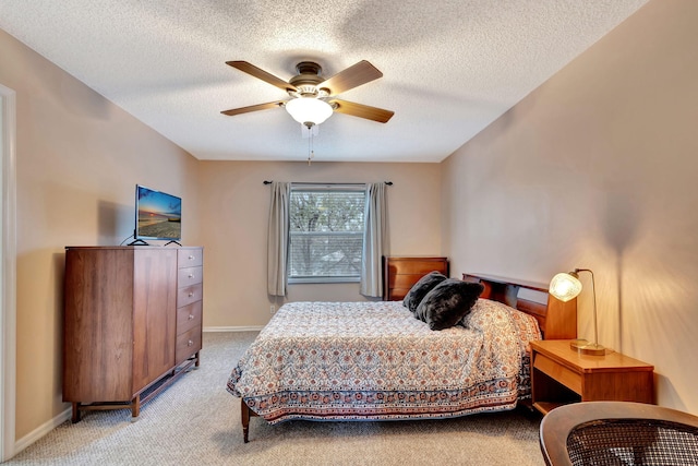 bedroom with a textured ceiling, light carpet, and ceiling fan