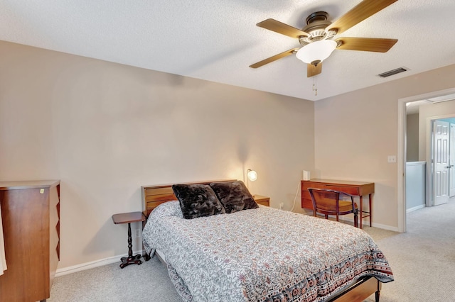 carpeted bedroom with ceiling fan and a textured ceiling