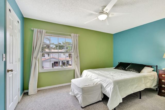 carpeted bedroom with ceiling fan and a textured ceiling