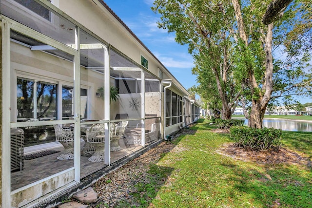 view of yard with a water view and glass enclosure