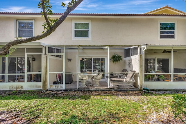 rear view of property with a yard, a patio area, and a sunroom