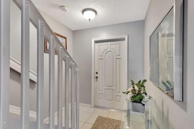 tiled entryway featuring a textured ceiling