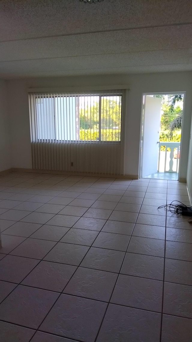 tiled empty room featuring plenty of natural light