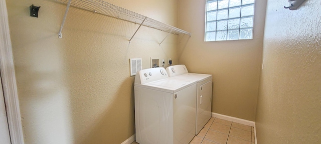 clothes washing area with light tile patterned flooring and independent washer and dryer