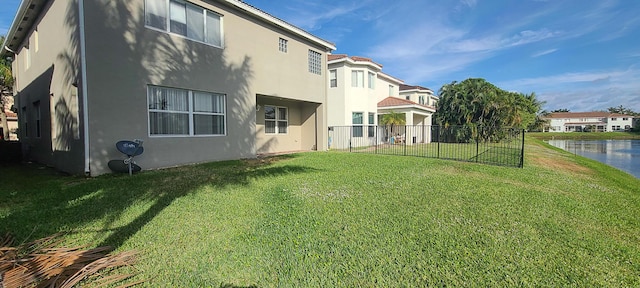 rear view of property with a lawn and a water view