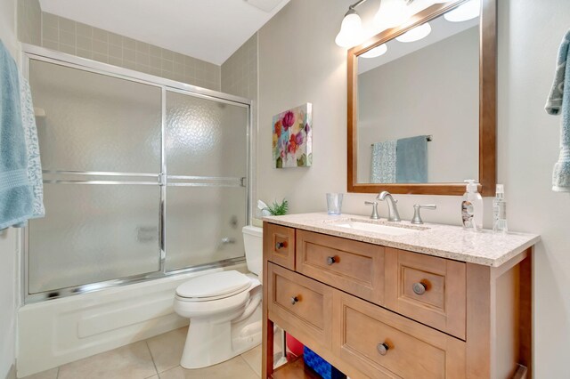 full bathroom featuring shower / bath combination with glass door, vanity, toilet, and tile patterned floors