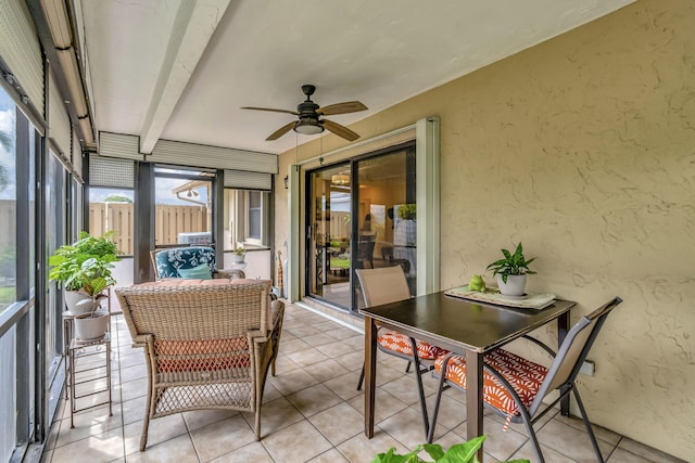 sunroom / solarium featuring beam ceiling and ceiling fan