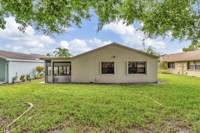 rear view of house featuring a yard and a sunroom