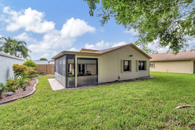 back of property with a yard and a sunroom