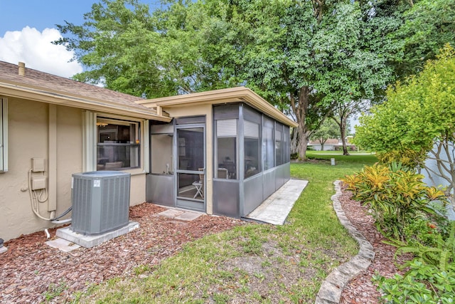 view of yard featuring a sunroom and central air condition unit