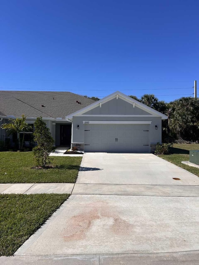 ranch-style home featuring a garage and a front lawn