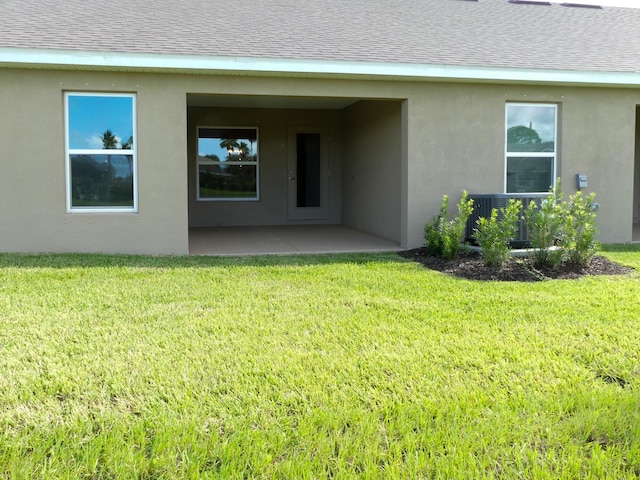 back of house with a yard and a patio