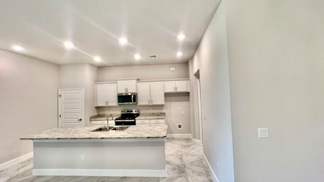 kitchen featuring a center island with sink, white cabinets, sink, and appliances with stainless steel finishes