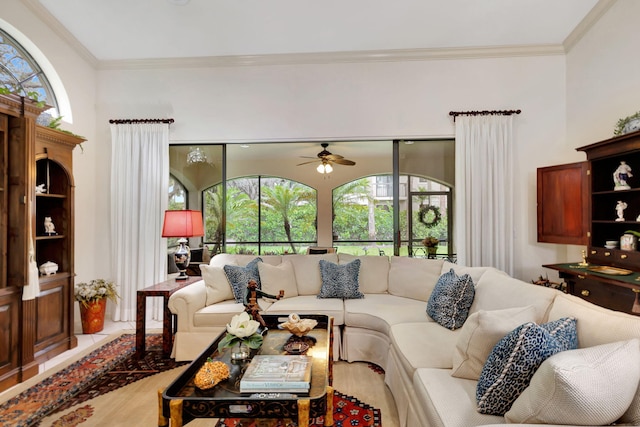 living room featuring light wood-type flooring, crown molding, and ceiling fan