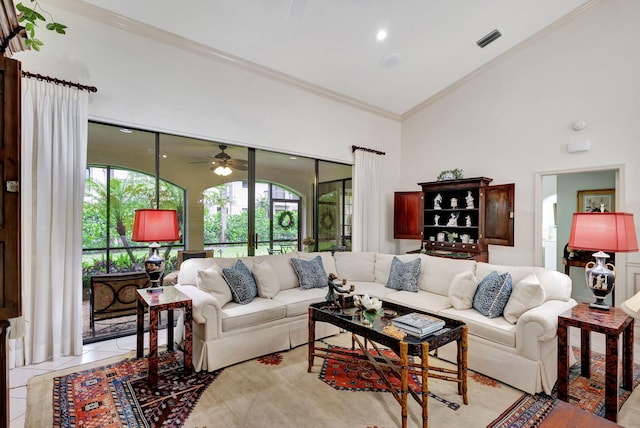 tiled living room featuring ceiling fan, ornamental molding, and high vaulted ceiling