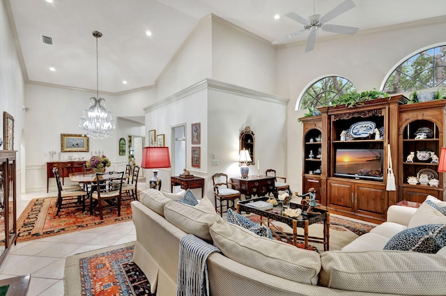 living room with ceiling fan with notable chandelier, a towering ceiling, light tile patterned floors, and ornamental molding