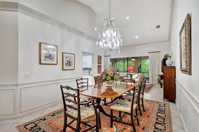 dining space with a notable chandelier, ornamental molding, and light tile patterned floors