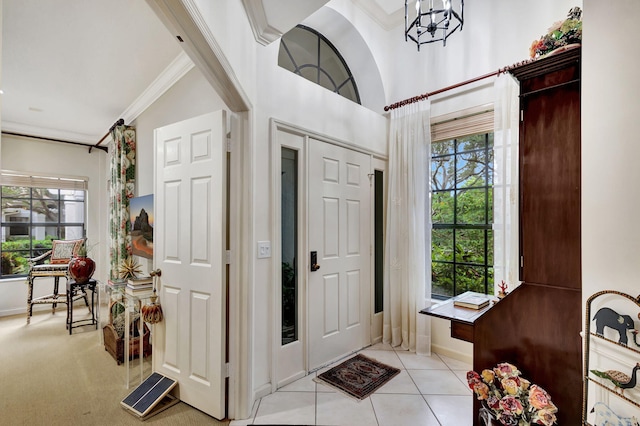 entryway featuring a healthy amount of sunlight, light tile patterned flooring, ornamental molding, and a notable chandelier