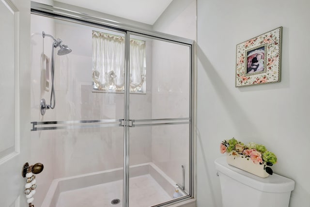 bathroom featuring toilet and an enclosed shower