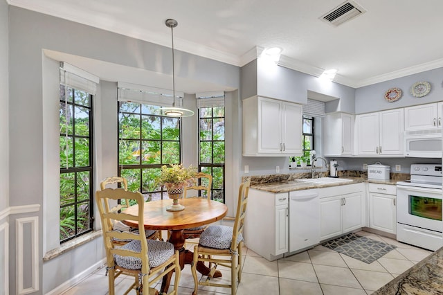 kitchen featuring white cabinets, dark stone counters, hanging light fixtures, and white appliances