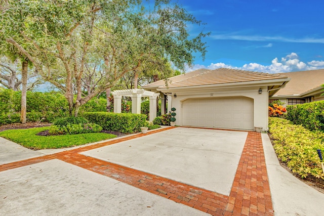 view of front of property featuring a pergola and a garage