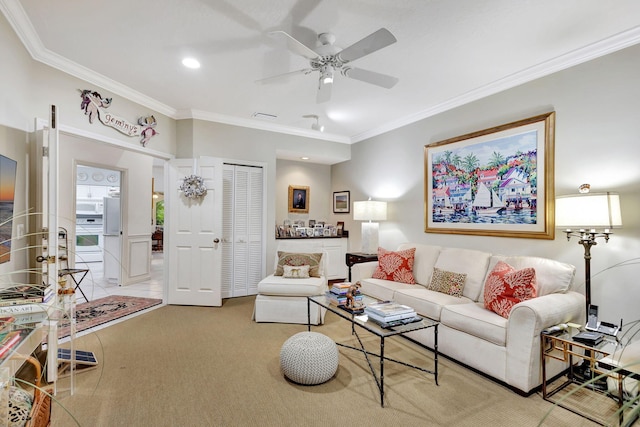 living room with ornamental molding, ceiling fan, and light colored carpet