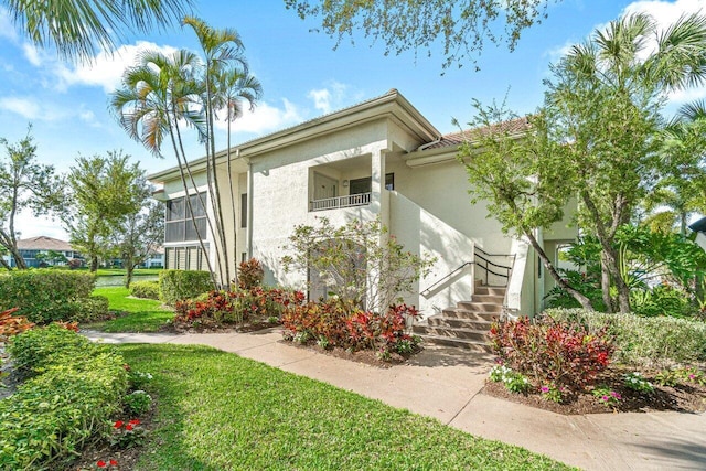 view of front of property featuring stairs and stucco siding