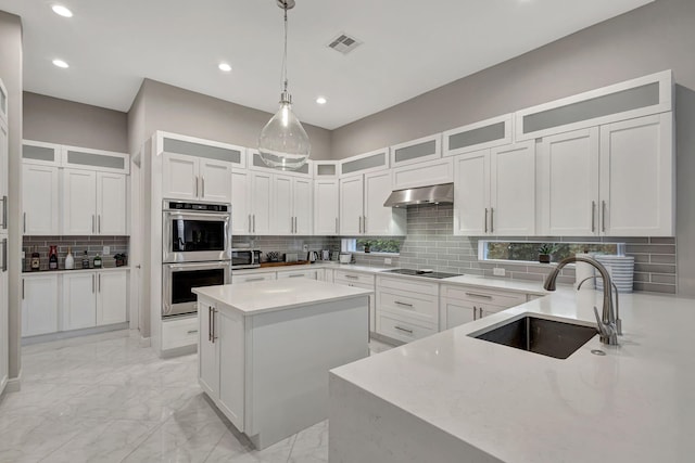 kitchen featuring pendant lighting, backsplash, stainless steel appliances, and sink