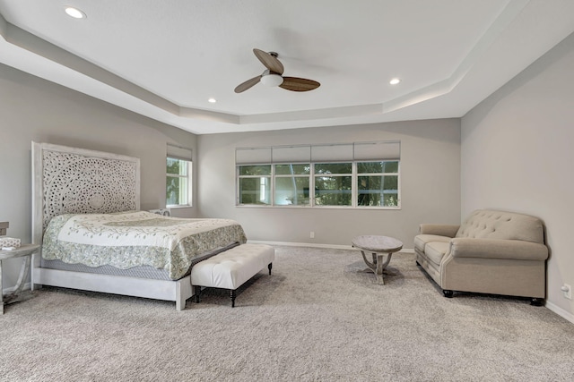 bedroom featuring carpet flooring, ceiling fan, and a raised ceiling