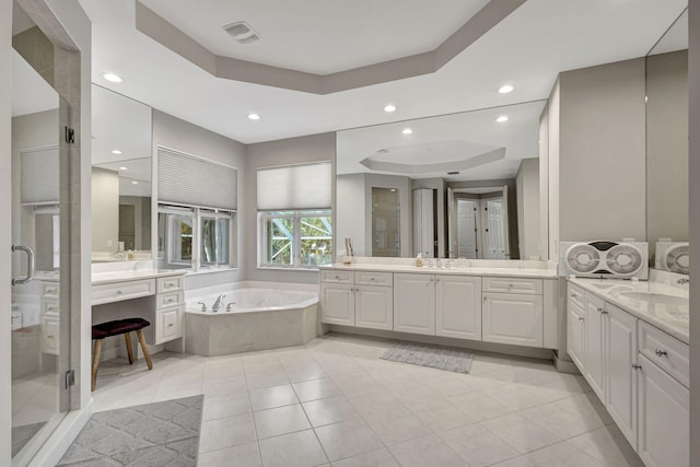 bathroom with vanity, a tray ceiling, tile patterned floors, and plus walk in shower