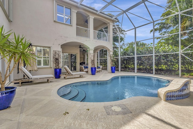 view of pool with ceiling fan, a patio, and glass enclosure