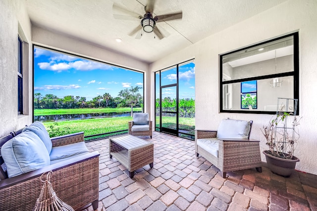 sunroom with a water view and ceiling fan