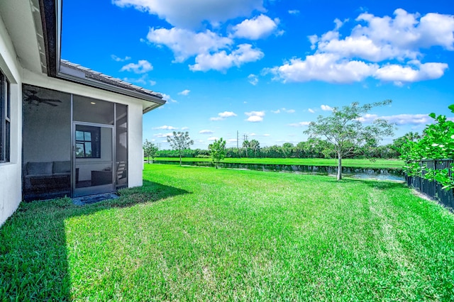 view of yard featuring a water view and a sunroom