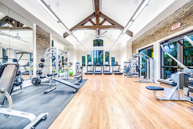 gym with high vaulted ceiling, ceiling fan, and hardwood / wood-style flooring