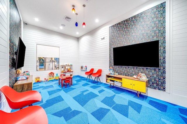 playroom featuring wood walls and carpet flooring