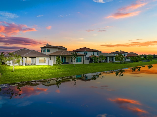 back house at dusk with a lawn