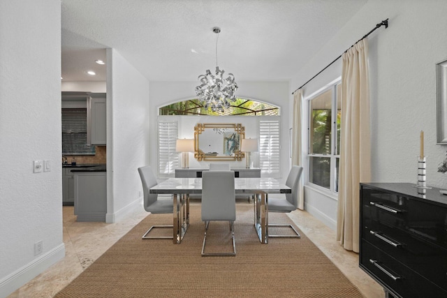 dining space with a textured ceiling and an inviting chandelier