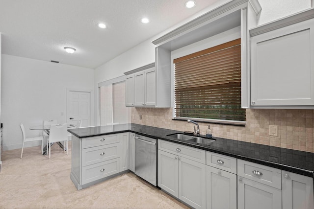 kitchen featuring backsplash, dishwasher, kitchen peninsula, and sink