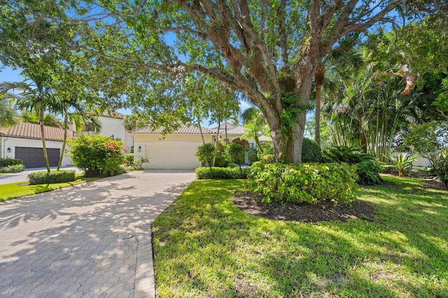 mediterranean / spanish house with a garage and a front lawn